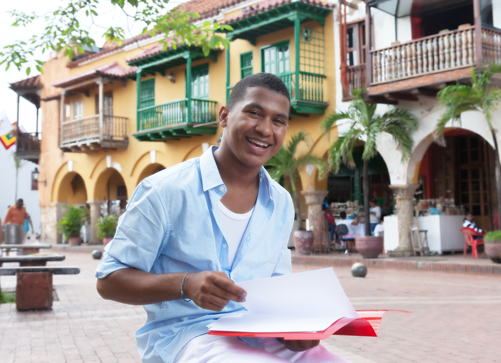 Estudiante latino organizando documentos para traducción oficial
